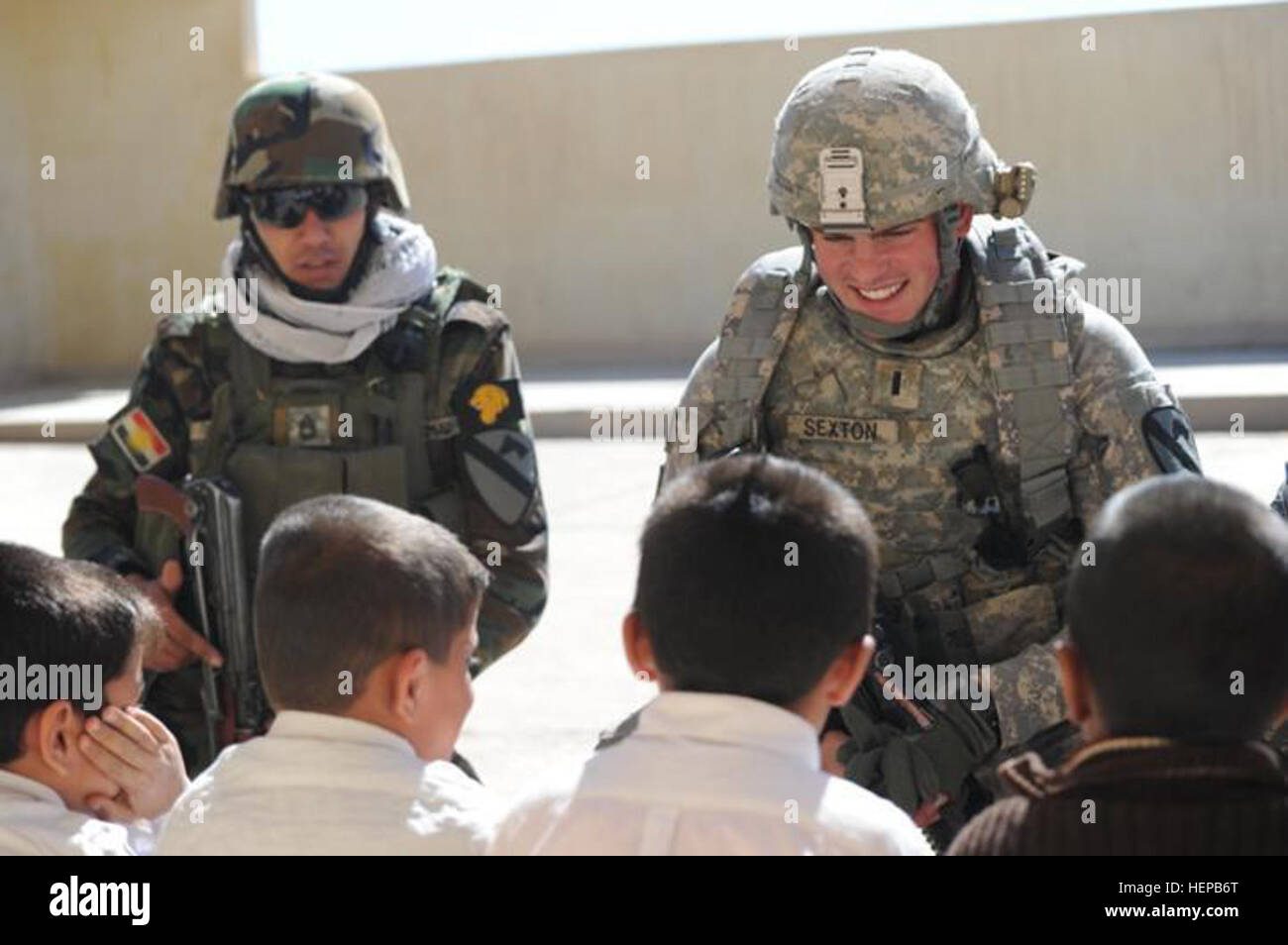 I bambini di Razada Scuola Primaria cantare il "A,B,C" in inglese per la 1Lt. Michael Sexton Jr., comandante di plotone, società A, 2° Battaglione, dodicesimo reggimento di cavalleria, 1a consigliare e assistere Task Force, 1a divisione di fanteria, e Sgt. 1. Classe Muhammad Salah Ahmad, sergente di plotone, 1° regionale brigata di guardia, Kirkuk combinate delle forze di sicurezza. I soldati del primo AATF in partnership con la città di Kirkuk CSF durante una comunità assistance mission 17 Marzo al villaggio Razada in Kirkuk, Iraq. (U.S. Esercito foto di PFC. McChesney hanno Alyxandra) insieme come uno 123456-A-AB123-123 Foto Stock