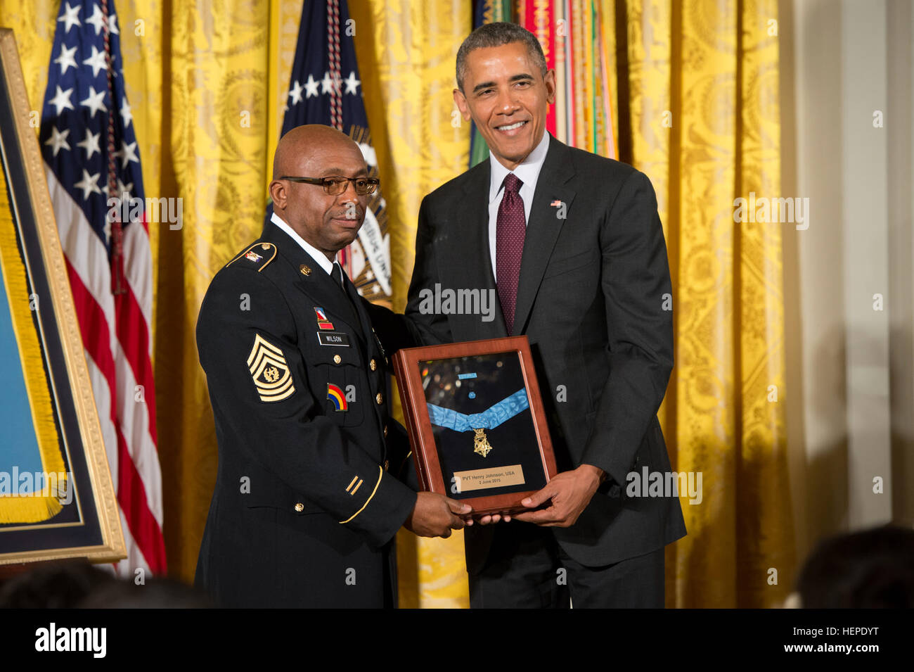 Il presidente Barack Obama conferisce la medaglia d'onore dell'esercito Sgt. Henry Johnson, accettando il suo nome è il comando Sgt. Il Mag. Louis Wilson, della New York National Guard, nella Sala Est della Casa Bianca, Giugno 2, 2015. Then-Pvt. Johnson, un afro-americano, si distinse come un membro di 369 Reggimento di Fanteria "Harlem Hellfighters', 93La divisione americana forze Expeditionary, durante le operazioni di combattimento contro il nemico sulle linee del fronte del fronte occidentale in Francia durante la guerra mondiale I. mentre di notte sentinella, 15 maggio 1918, Johnson e un compagno soldato, Pvt. Needham Roberts, rec Foto Stock