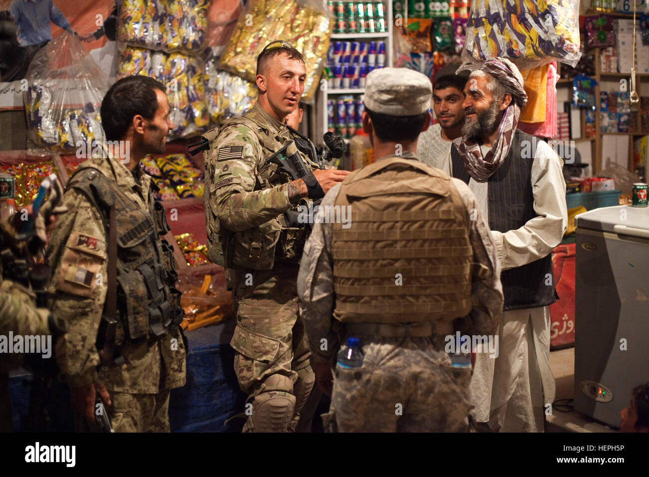 Un nazionale afghano di ordine civile funzionario di polizia parla di un negozio locale proprietario durante una missione guidata dalla U.S. I soldati dell esercito assegnato alla società alfa, 5° Stormo, 1° reggimento di cavalleria, XXV divisione di fanteria, per pattugliare le strade al di fuori della lotta Post operativo 8-1, nel centro città di Kandahar, Afghanistan, 29 maggio. L'obiettivo della missione è quello di impostare la tattica di punti di controllo per veicoli di ricerca/gli occupanti e per raccogliere atmospherics dalla popolazione generale. Flickr - STATI UNITI Esercito - Shop Talk Foto Stock