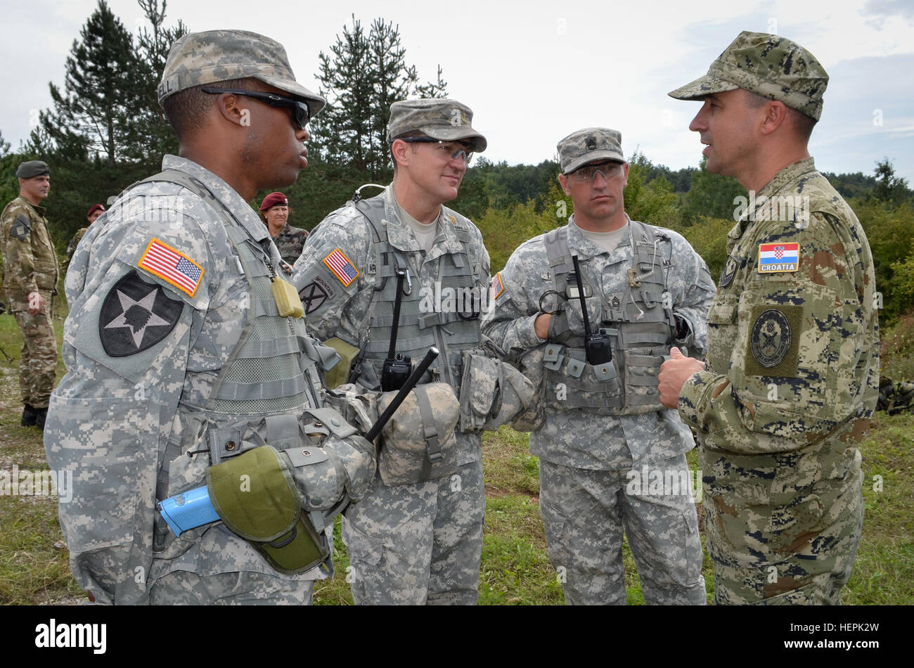 Stati Uniti Esercito Capt. Kye Pannell, il Mag. James Armstrong e Sgt 1a classe Nicholas Lombard dell'osservatore Grizzly coach trainer (ott Team) parla con un esercito croato officer dopo una formazione difensiva lane è stata completata durante la risposta immediata 15 in Slunj, Croazia. Risposta immediata 15 è una multinazionale, vigili del livello, posto di comando esercizio utilizzando computer assisted simulazioni e formazione sul campo di esercizi in Croazia e Slovenia.Le esercitazioni e simulazioni sono costruite su una decisa azione scenario di base e sono progettati per migliorare la stabilità regionale e rafforzare la capacità del partner e migliorare Foto Stock