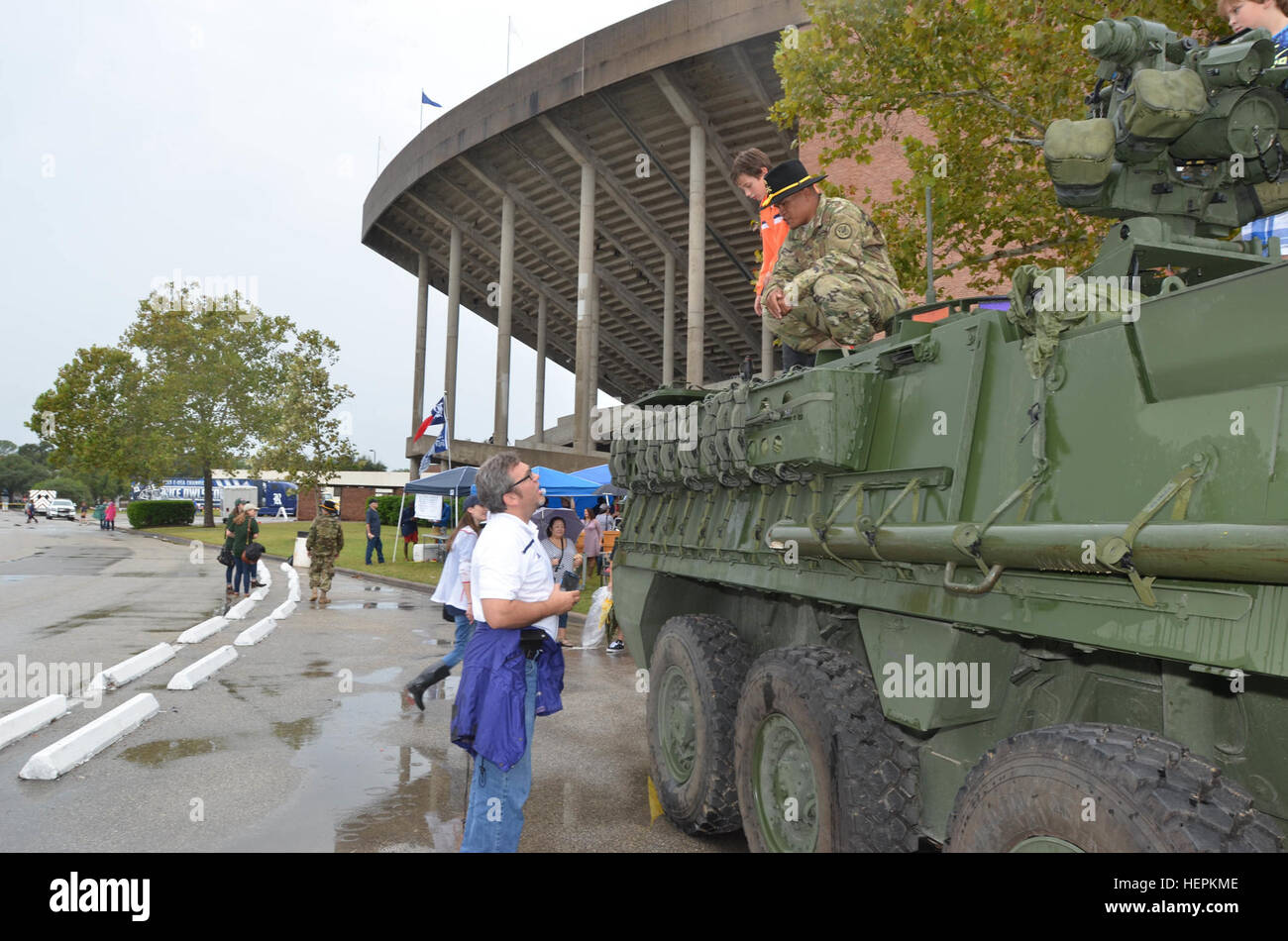 In cima al suo Stryker, un soldato con il 2° Stormo "Sciabola", 3d della Cavalleria parla di un tifoso durante l esercito contro il gioco di riso 24 Ottobre presso la Rice University di Houston. Il gruppo è stato uno dei due Fort Hood unità per visualizzare apparecchiature al di fuori della Rice University's Stadium. (Foto di Staff Sgt. Tomora Clark, 3d della cavalleria degli affari pubblici NCOIC) Prima Squadra mostra la potenza di fuoco e spirito di cavalleria a gioco Army-Rice 151024-A-VH746-019 Foto Stock