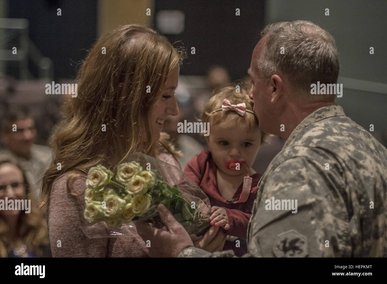 Brig. Gen. Richard Sele, 108th comando di formazione (IET) vice comandante generale, dà il suo nipote un bacio pur presentando un bouquet di rose giallo a sua figlia per i suoi contributi e pazienza, per l'esercito come un membro della famiglia. Sele è stato promosso al rango di Briga. Gen. durante una cerimonia ospitata dal magg. Gen. Daniel Ammerman, Esercito degli Stati Uniti per gli affari civili e Pychological Operations Command comandante generale, al volo e le operazioni speciali Museum di Fayetteville, N.C., 25 ottobre 2015. Sele, un longtime gli affari civili soldato, assume per Briga. Gen. A. Ray Royalty come d Foto Stock