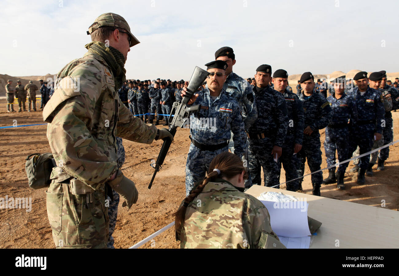 Un Reale Danese soldato dell'esercito, a sinistra con la Task Force Al Asad, mani fuori un M16 fucile per un iracheno forza di polizia federale partecipante al suo primo giorno di addestramento militare di Al Asad Air Base, Iraq, Marzo 15, 2016. Finanziamenti per l'acquisto di attrezzature è stata assegnata dall'Iraq addestrare ed equipaggiare il fondo (ITEF), che gli Stati Uniti Congresso stanziati per fornire assistenza ai militari e di altri servizi di sicurezza associate con il governo dell'Iraq. ITEF, facilitata dalla Combined Joint Task Force - Funzionamento inerenti risolvere, fornisce un essenziale armi e attrezzature per le Forze di Sicurezza Irachene come parte dell'buildi Foto Stock