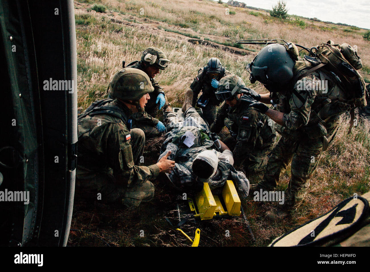 Sgt. Jamie Fox (a destra), un combattimento Medic assegnato alla società C., 2° Battaglione, 227th reggimento di aviazione, 1° aria brigata di cavalleria guide soldati polacchi verso dopo la risposta a un nove-line medevac durante l'esercizio Anakonda 2016 (un16) a Miroslawiec Air Base, Polonia, 11 giugno 2016. Un16 un polacco-led, multinazionale di evento di formazione in funzione da giugno 7-17, coinvolge circa 31.000 partecipanti provenienti da più di 20 nazioni ed è il principale evento di formazione per gli Stati Uniti Esercito europeo. Live Mascal Formazione a esercitare Anakonda 2016 160611-A-YT518-003 Foto Stock