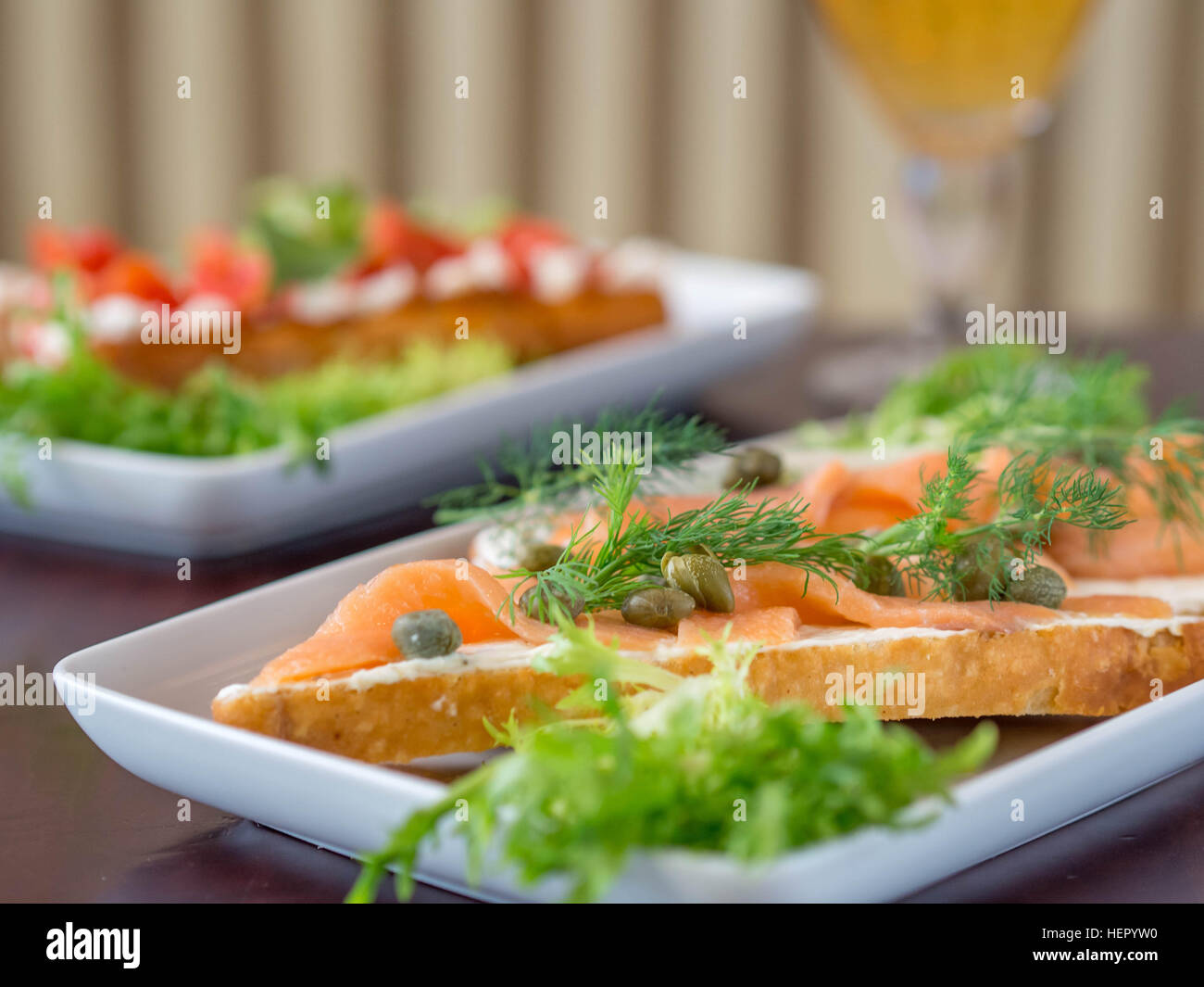 Salmone affumicato e cappero aprire panini con un bicchiere di birra Foto Stock