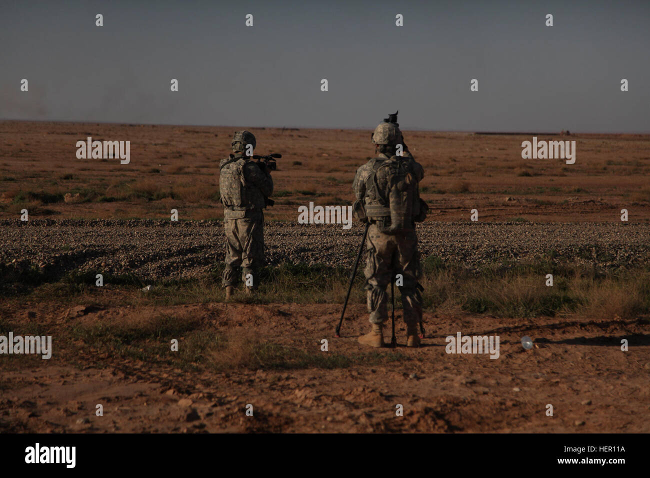 Stati Uniti Army Sgt. Brandon Bolick, 982nd combattere la fotocamera e SPC. Jesse Youngstrom, XXV divisione di fanteria, stanno prendendo le riprese video di Strykers tubo di sparo-lanciato, otticamente inseguito, filo-missili guidati su una gamma di serbatoio a Diyala provincia, Kirkush formazione militare Base, Iraq, 28 marzo 2011. Lo scopo di questa documentazione è di fornire le riprese per il futuro di video di formazione. (Foto: PFC. Nikko-Angelo Matos) TOW Missile esame 280311-A-YV529-003 Foto Stock