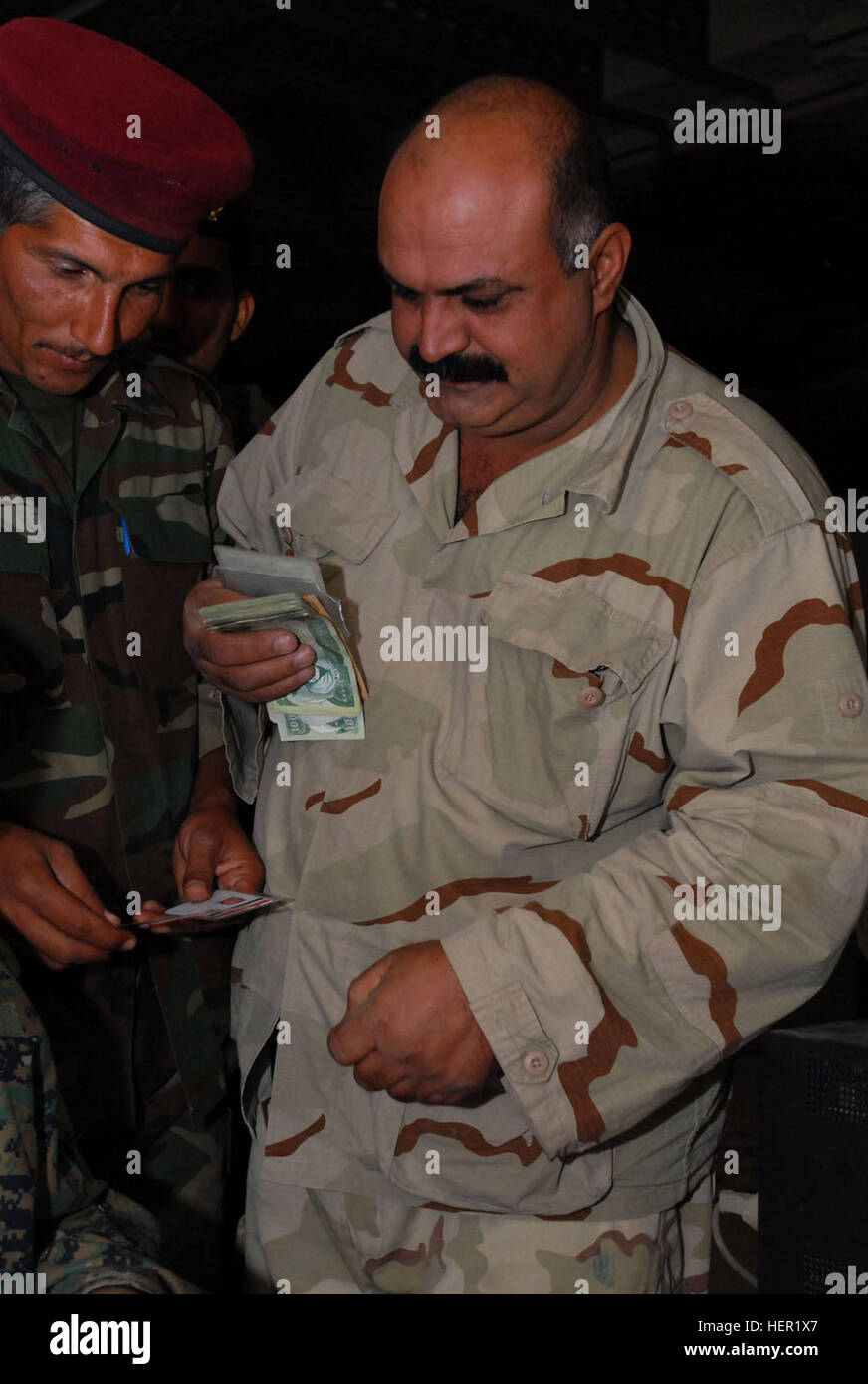Abdul Hadi Fathallah Mahidi, figlio di Iraq stati dal quartiere Adhamiyah di Bagdad, riceve il suo stipendio mensile da parte delle autorità irachene a combattere avamposto Apache nel quartiere Adhamiyah di Bagdad, nov. 13. Questa era la prima volta che il governo iracheno ha pagato il SoI poiché essi hanno assunto il controllo dell'organizzazione dalle forze della coalizione. In precedenza il SoI era stato pagato dalla coalizione. Governo dell'Iraq rende primi Figli dell'Iraq il pagamento in Adhamiyah 128641 Foto Stock