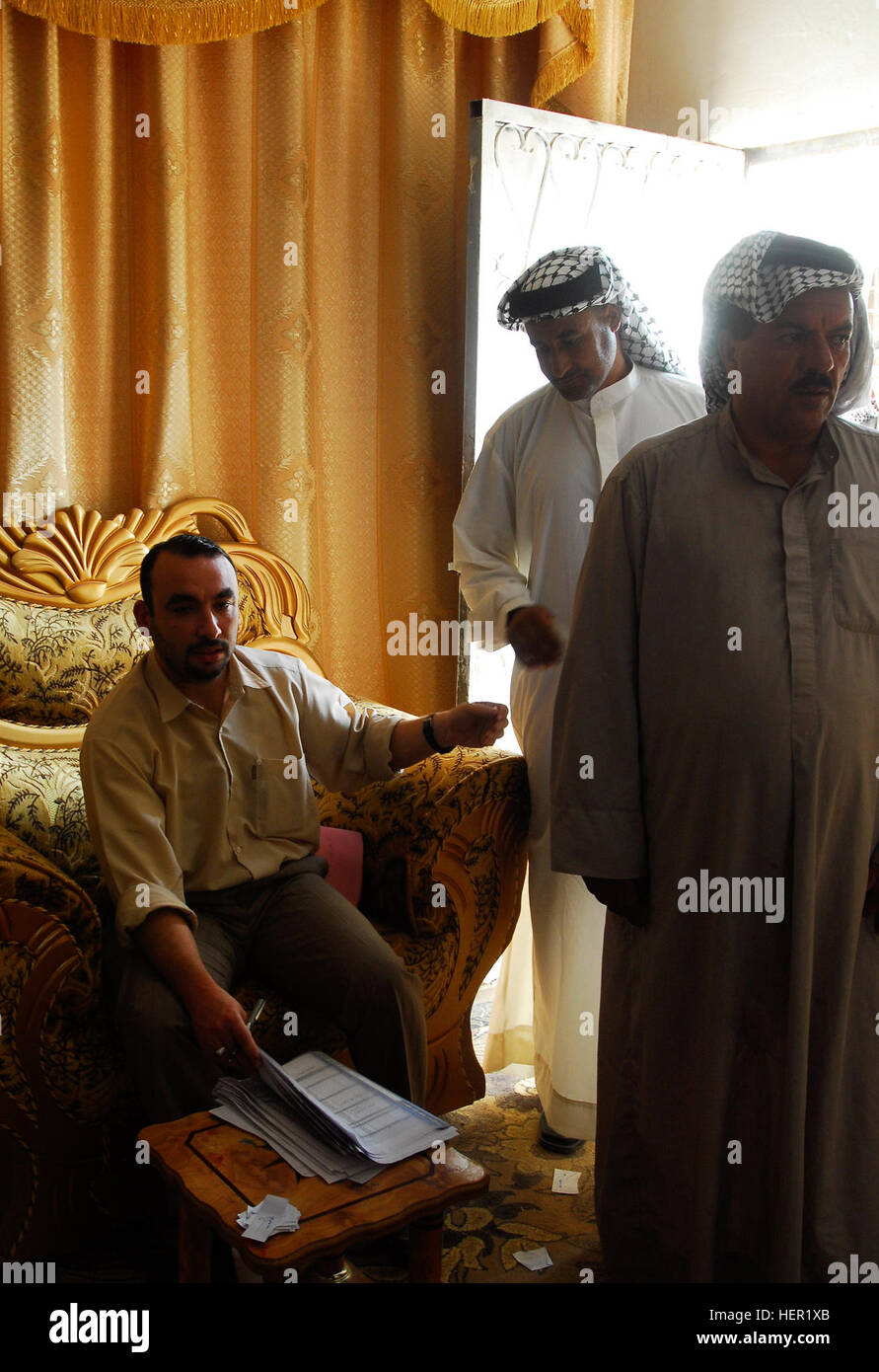 Un governo iracheno i controlli ufficiali figli dell Iraq le carte di identità e i record che hanno ricevuto il pagamento dal governo indiano per i loro servizi a ostacolare il movimento di esplosivi in tutto l'Iraq da manning checkpoint in tutto il Mahmudiyah Qada, all'esercito iracheno in base Lutifiyah, nov. 13. Lutifiyah figli dell Iraq pagato dal governo dell'Iraq 129635 Foto Stock