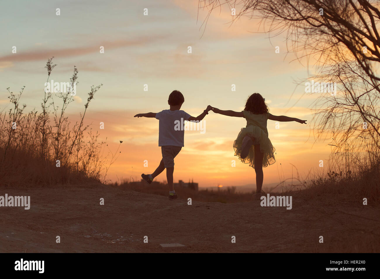 Ragazzo e una ragazza Holding Hands, ballare al tramonto Foto Stock