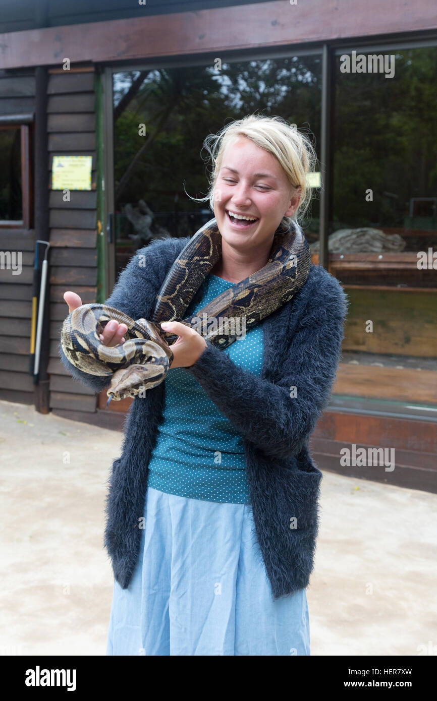 Giovane donna bionda con un serpente intorno al collo, Lawnwood Snake santuario, Plettenberg Bay, Sud Africa Foto Stock