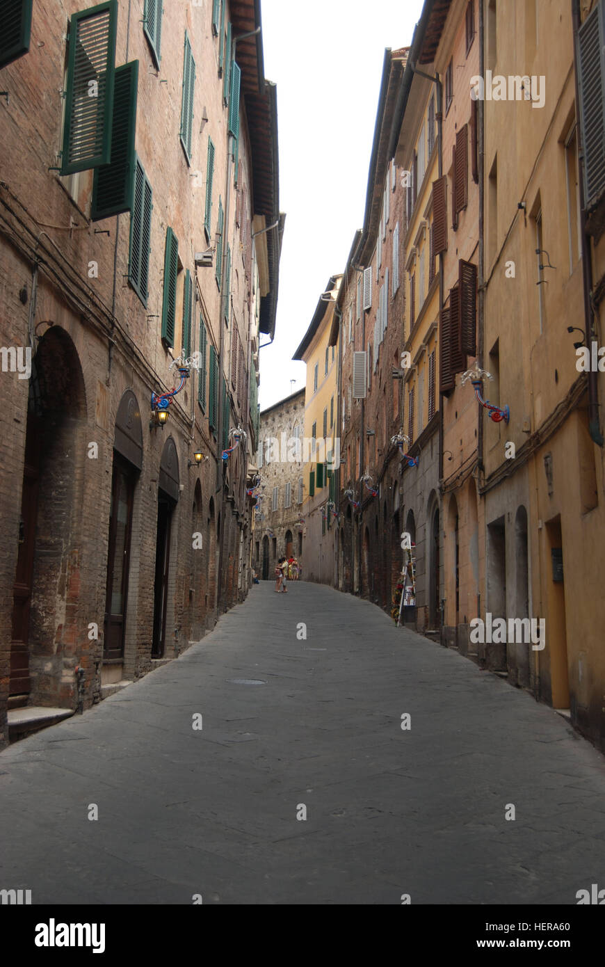 Paar umarmt sich in einer sonst menschenleeren Gasse in der Altstadt von Siena, Toskana Foto Stock