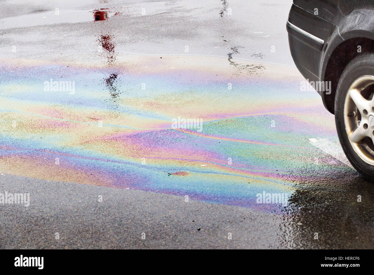 Striature di olio su asfalto bagnato, Foto Stock