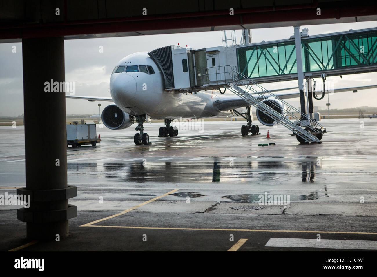 Ponte di imbarco inserito con aereo in aeroporto Foto Stock