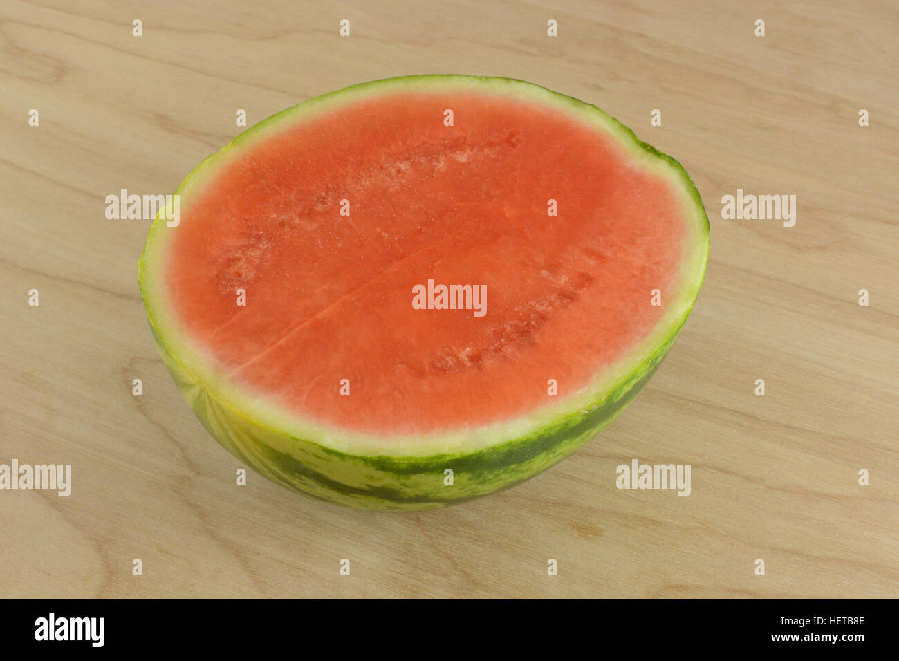 La metà delle fette di cocomero senza semi su legno Foto Stock