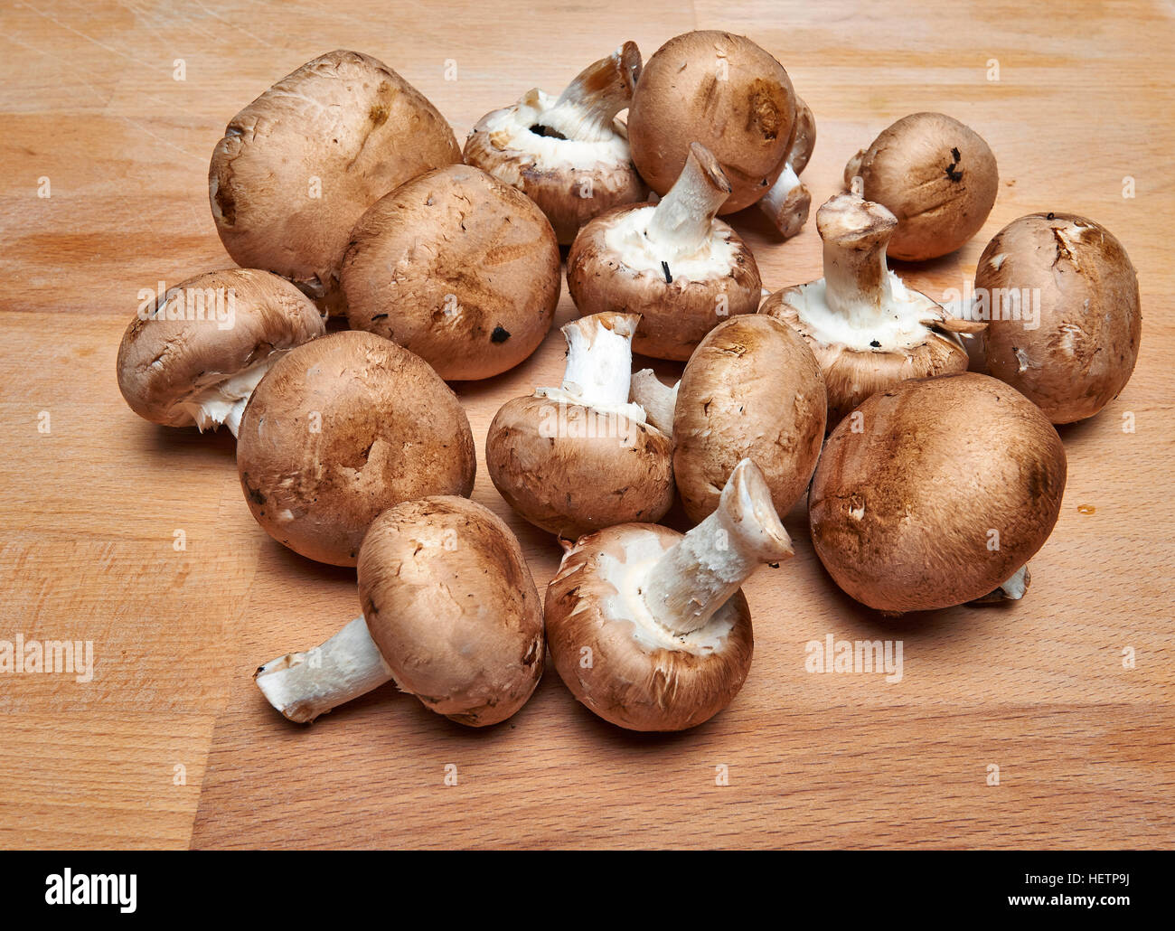 Gran Royal di funghi champignon con varietà marrone su un tagliere di legno. Foto Stock