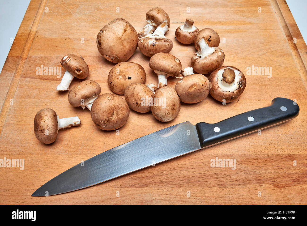 Gran Royal di funghi champignon con varietà marrone su un tagliere di legno. Foto Stock