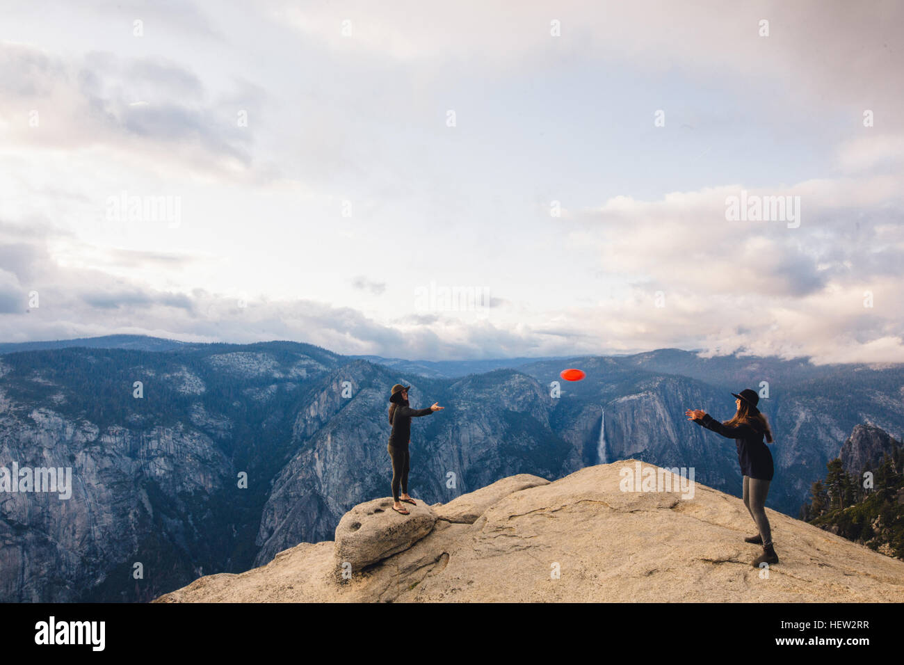 Giovane donna giocando con il flying disc in cima alla montagna che domina il Parco Nazionale di Yosemite in California, Stati Uniti d'America Foto Stock