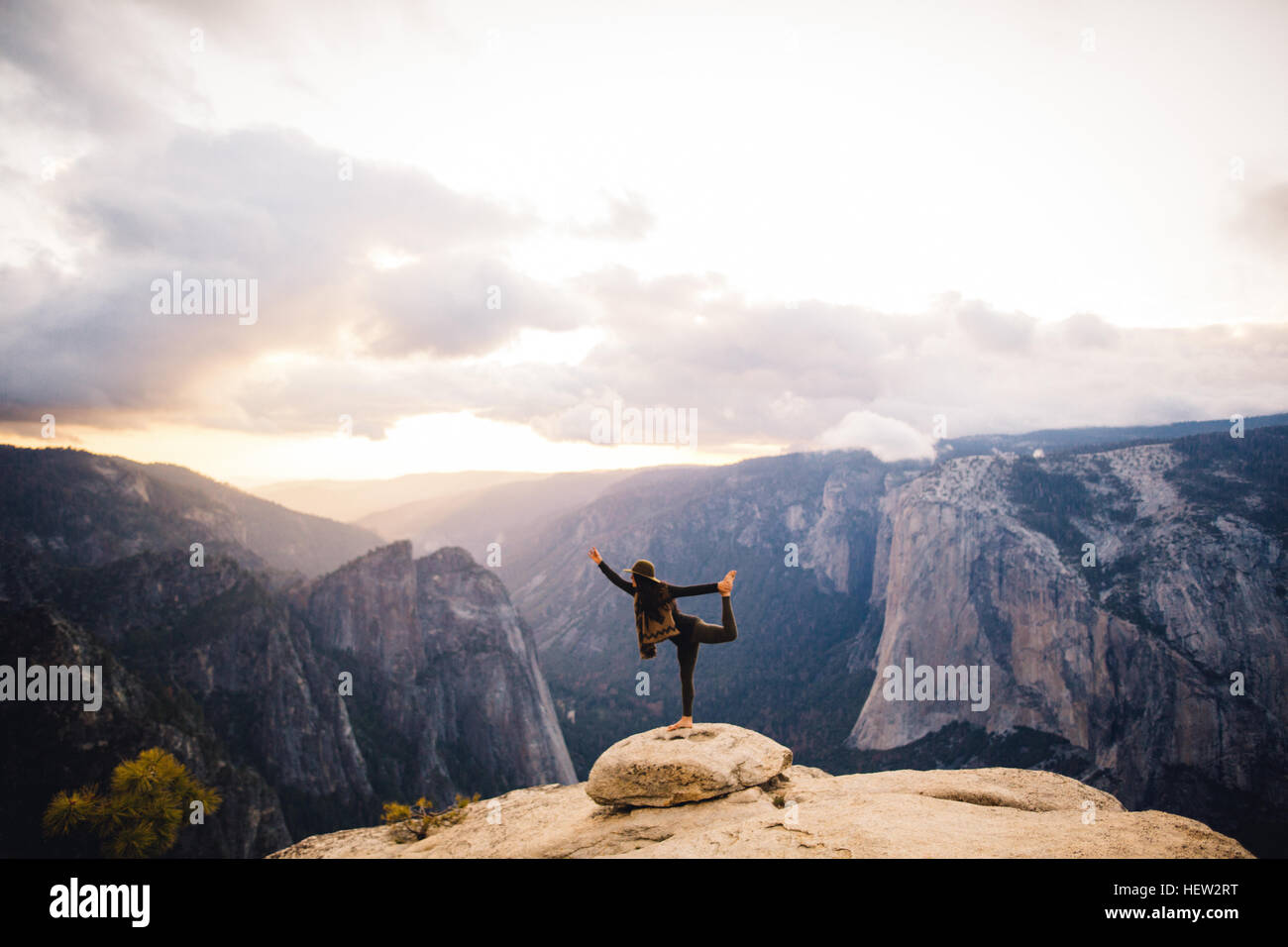 Giovane donna in piedi di yoga posa in cima alla montagna che domina il Parco Nazionale di Yosemite in California, Stati Uniti d'America Foto Stock