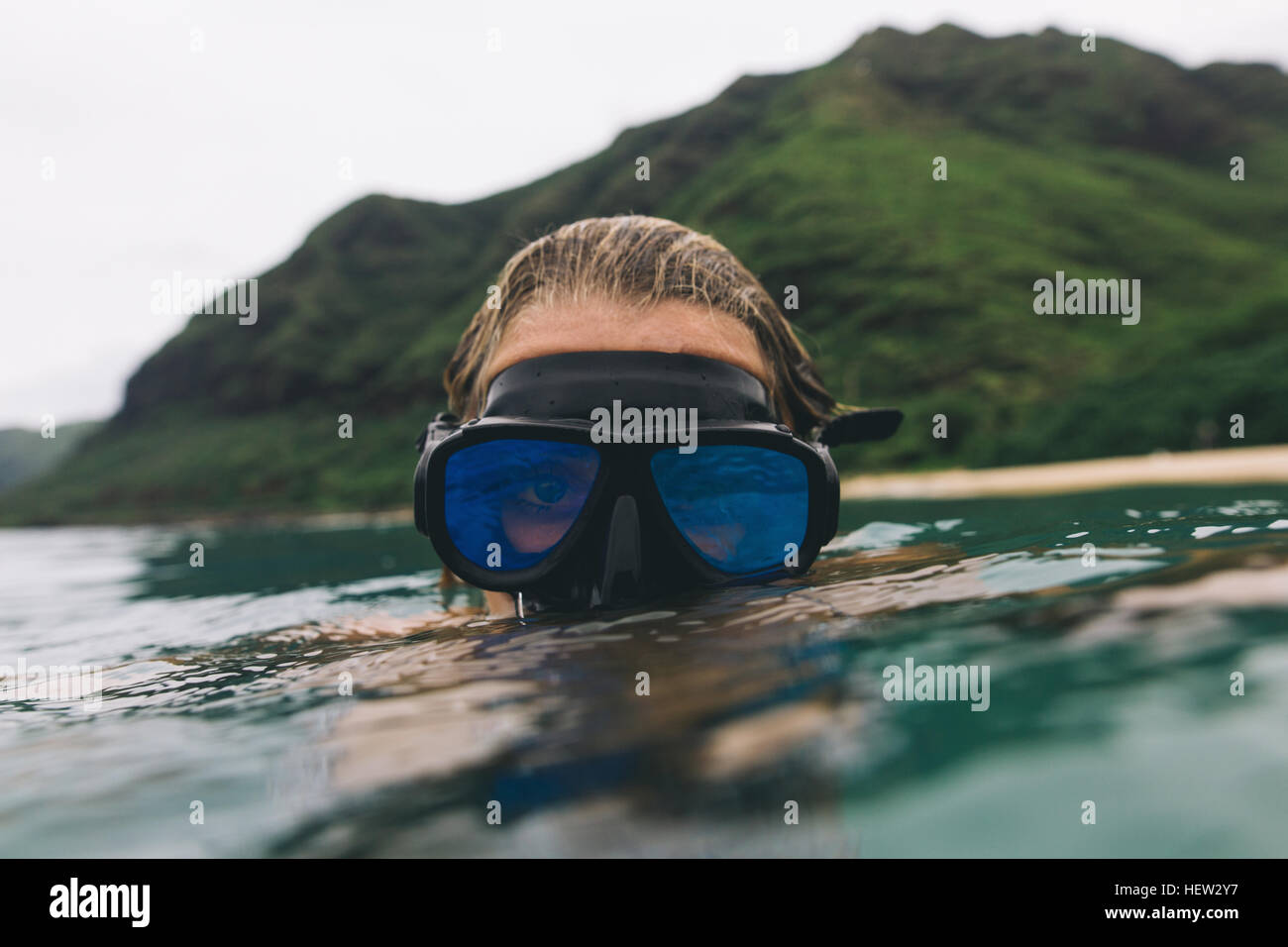 Nuotatore che indossa gli occhiali di protezione in prossimità della superficie del mare Foto Stock