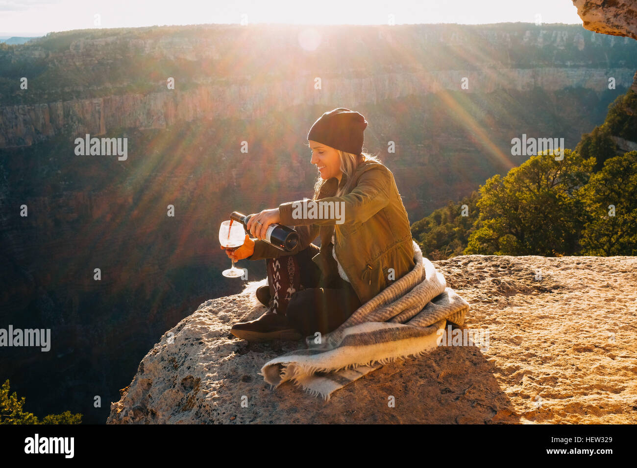 Donna versando un bicchiere di vino sul bordo del Grand Canyon, Arizona, Stati Uniti d'America Foto Stock