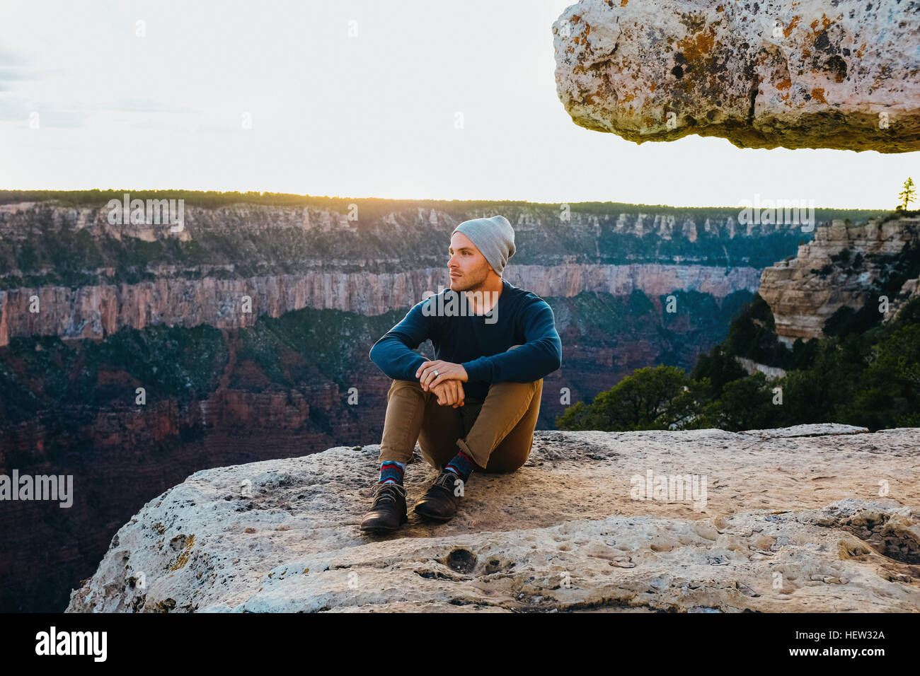 Uomo seduto sul bordo del Grand Canyon, Arizona, Stati Uniti d'America Foto Stock