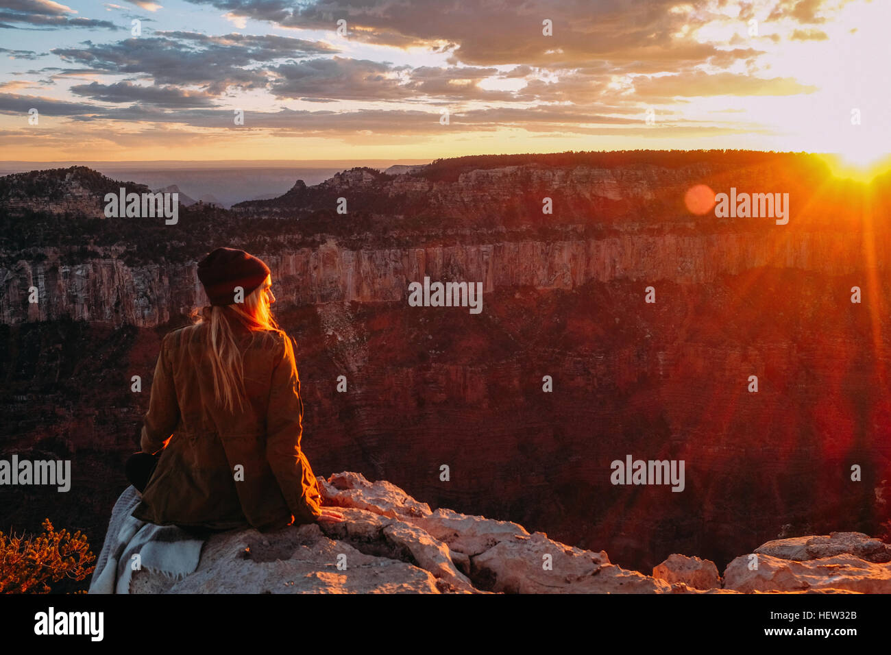 Donna seduta sul bordo del Grand Canyon, Arizona, Stati Uniti d'America Foto Stock