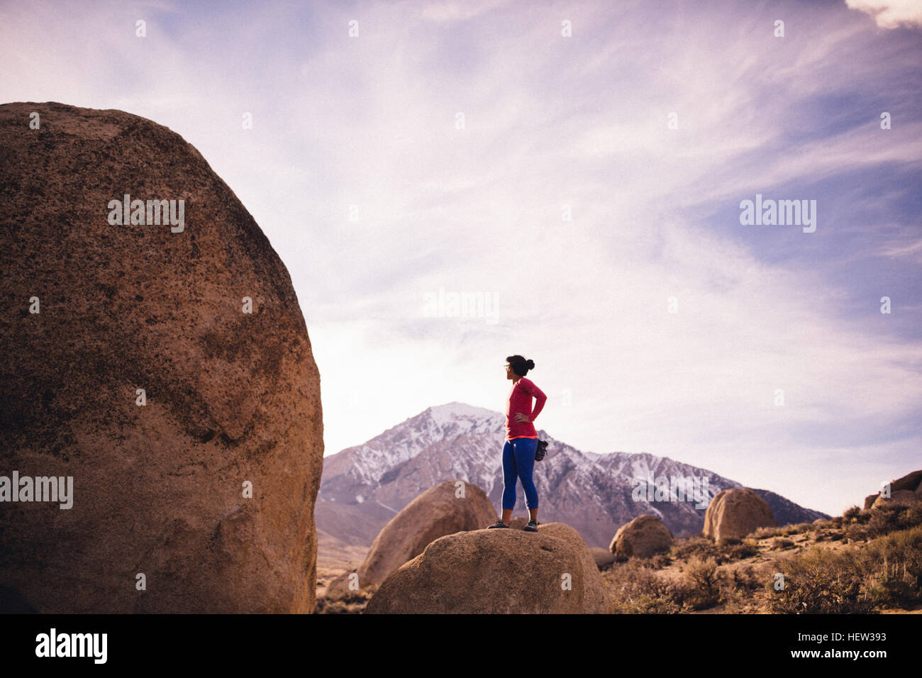 Donna in piedi sulla sommità della roccia che guarda lontano, latticello massi, Vescovo, CALIFORNIA, STATI UNITI D'AMERICA Foto Stock