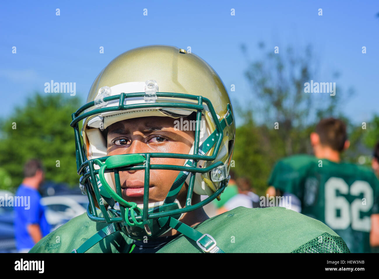 Ritratto maschile teenage giocatore di football americano che indossa il casco al campo da gioco Foto Stock