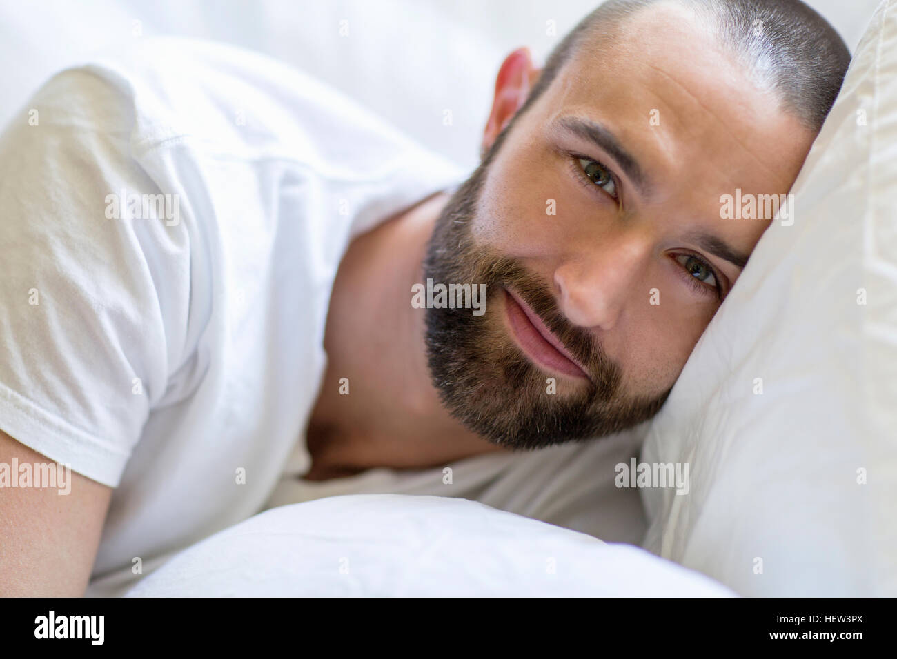 Ritratto di metà uomo adulto che giace nel letto Foto Stock