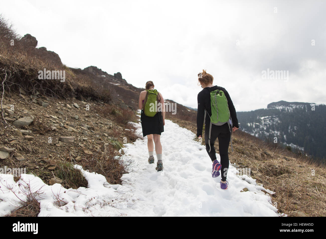 Due giovani donne trekking lungo la mountain-lato, vista posteriore, Silver Star Mountain, Washington, Stati Uniti d'America Foto Stock