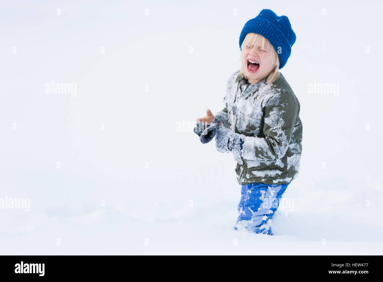 Ragazzo nella neve profonda piangere Foto Stock