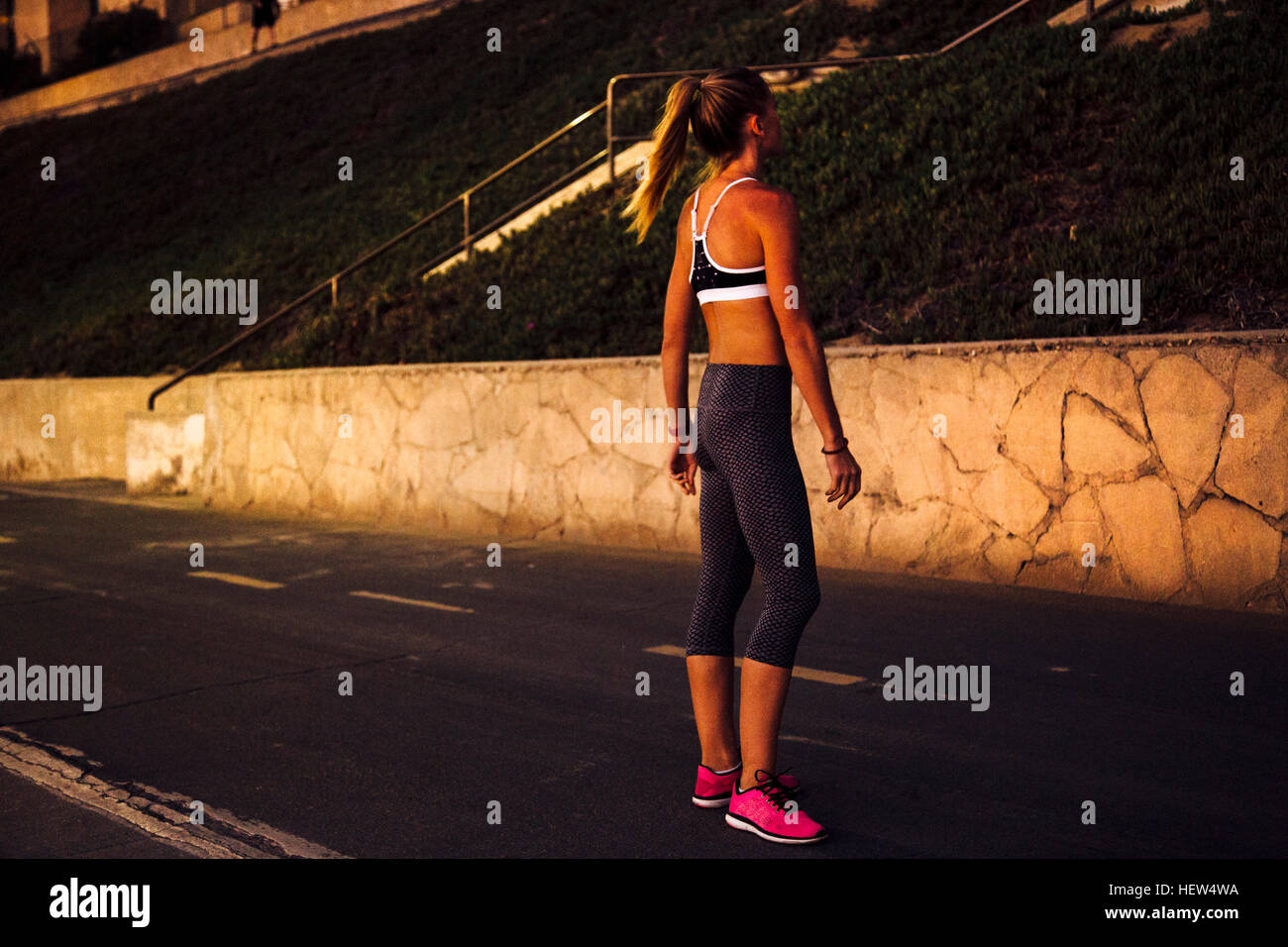 Donna che indossa spandex in piedi in strada di notte Foto Stock