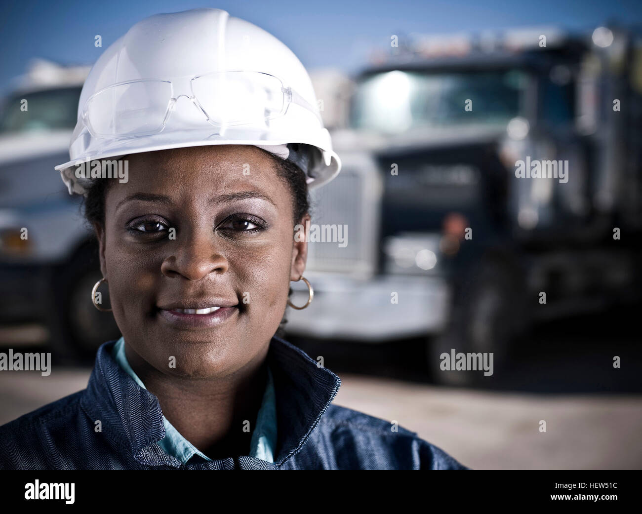 Ritratto di lavoratrice in elmetto di fronte all impianto di riciclaggio camion Foto Stock