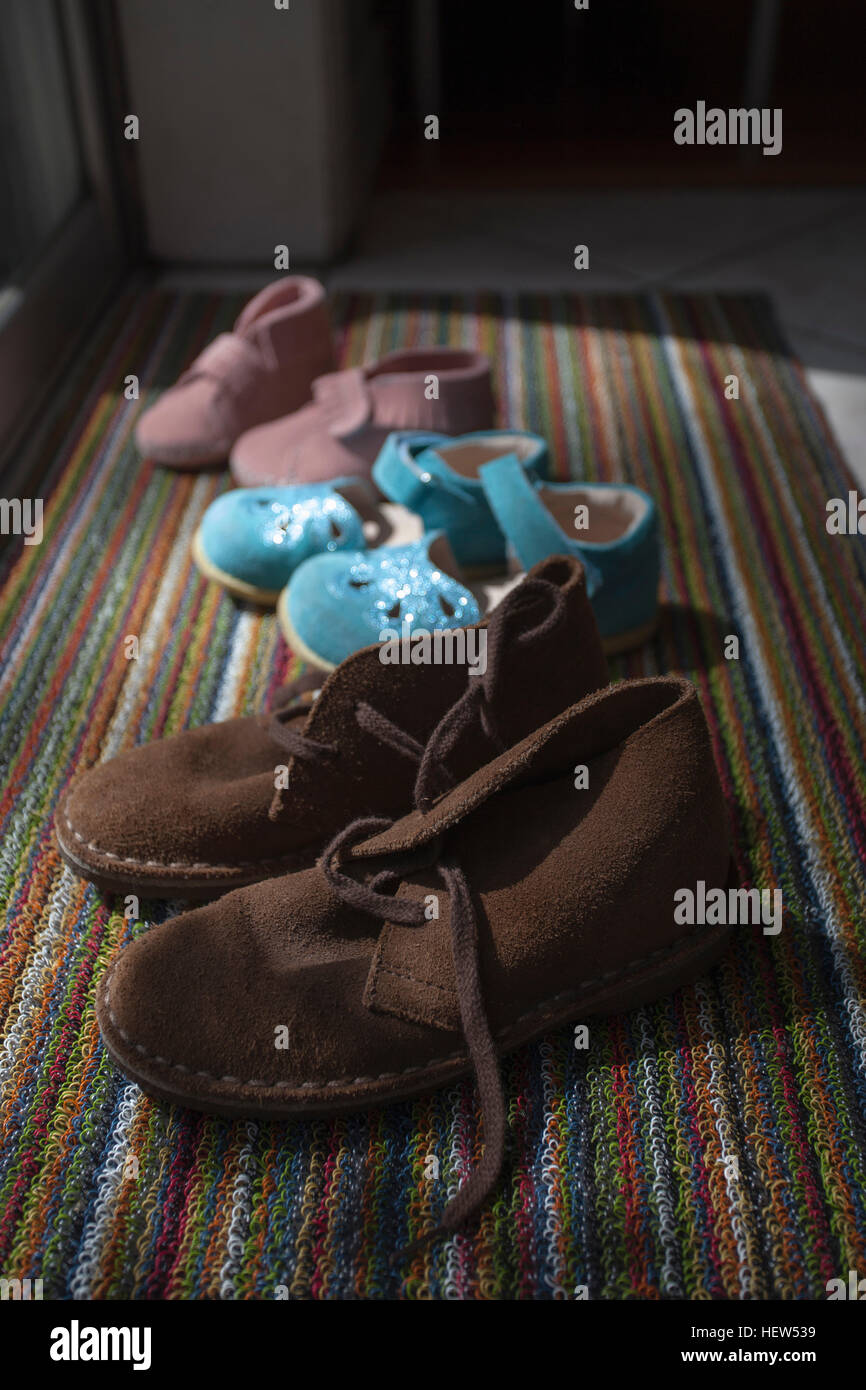 Dimensioni diverse scarpe allineate su zerbino Foto Stock