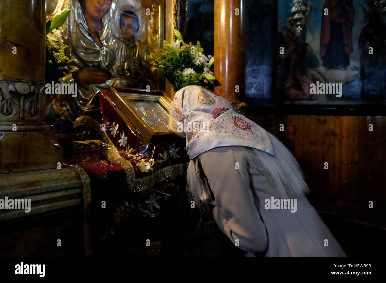 Una chiesa russo-ortodossa adoratore di pregare all interno della chiesa dell Assunzione noto anche come chiesa del sepolcro di Santa Maria o la tomba di Maria Vergine, situato lungo il torrente Kidron prima di Getsemani ai piedi del Monte degli Ulivi, Gerusalemme est Israele Foto Stock