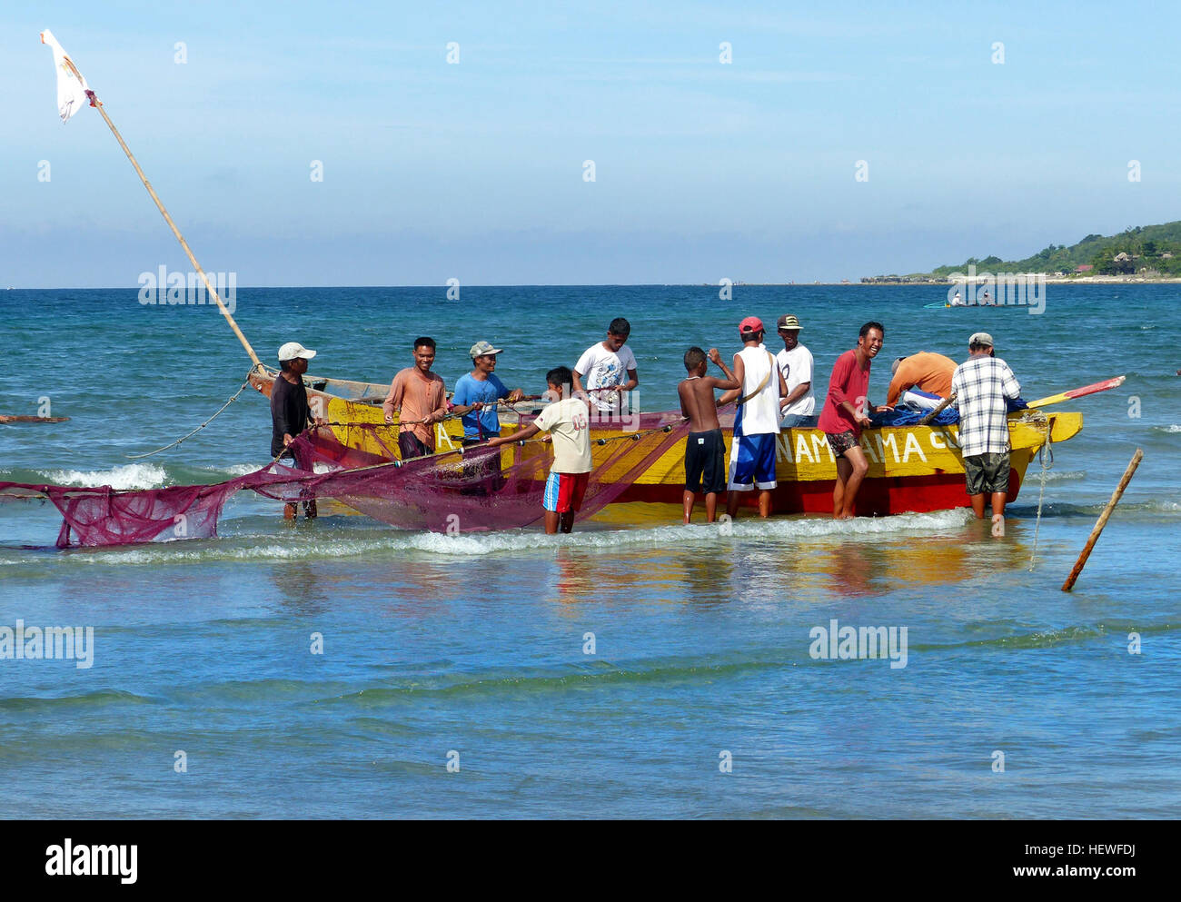 A Currimao, nelle Filippine, vengono ancora utilizzati metodi di pesca tradizionali, tra cui reti da pesca di tre chilometri. I pescatori cantano la canzone dell'Ilocano "Pamulinawen" per sincronizzare i loro sforzi di pesca, una pratica che è stata tramandata da generazioni. Foto Stock