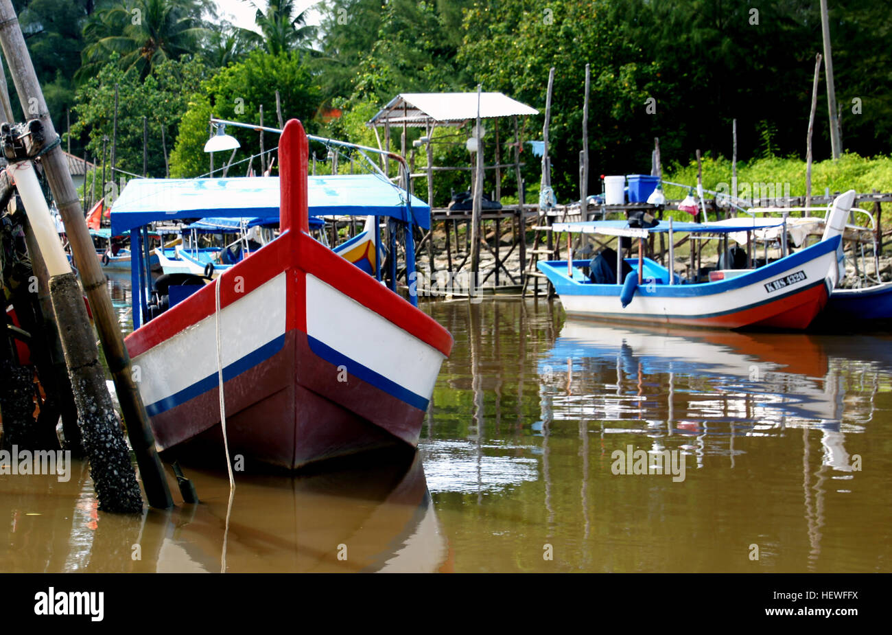 La pesca in Malesia è una parte significativa dell'economia locale, con barche colorate utilizzate nei metodi di pesca tradizionali. I colori vivaci delle barche aggiungono un tocco culturale unico alla scena della pesca costiera. Foto Stock