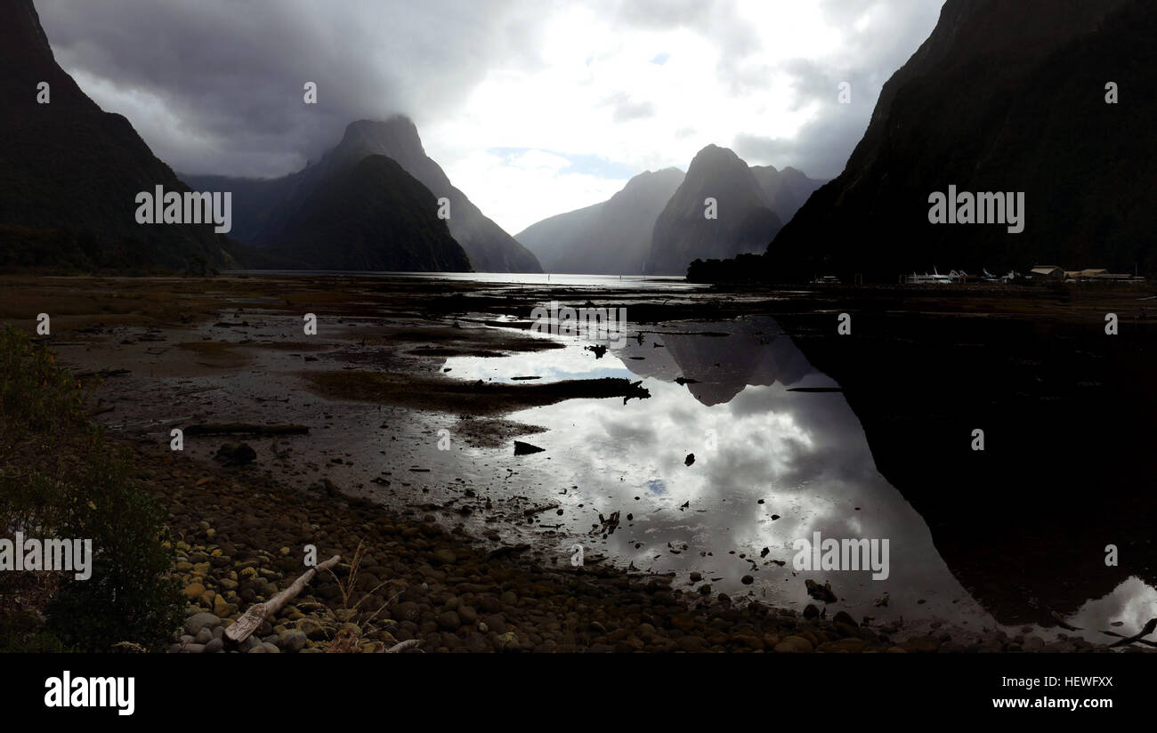 Bagnato o ammenda, Milford Sound è incredibilmente grand. Mitre Peak magnetises fotografi e il fiordo di rocce a strapiombo eccitare entrambe ammirazione e timore. Milford Sound è di gran lunga il più noto di tutti i fiordi e il solo che possa essere accessibile dalla strada. Si trova a circa 16km dalla testa del fiordo del mare aperto, il che significa che i visitatori possono viaggiare comodamente la lunghezza del fiordo di oceano aperto e tornare su una delle molte opzioni di crociera disponibile in 1 ½ a 2 ore il tempo di crociera. Foto Stock