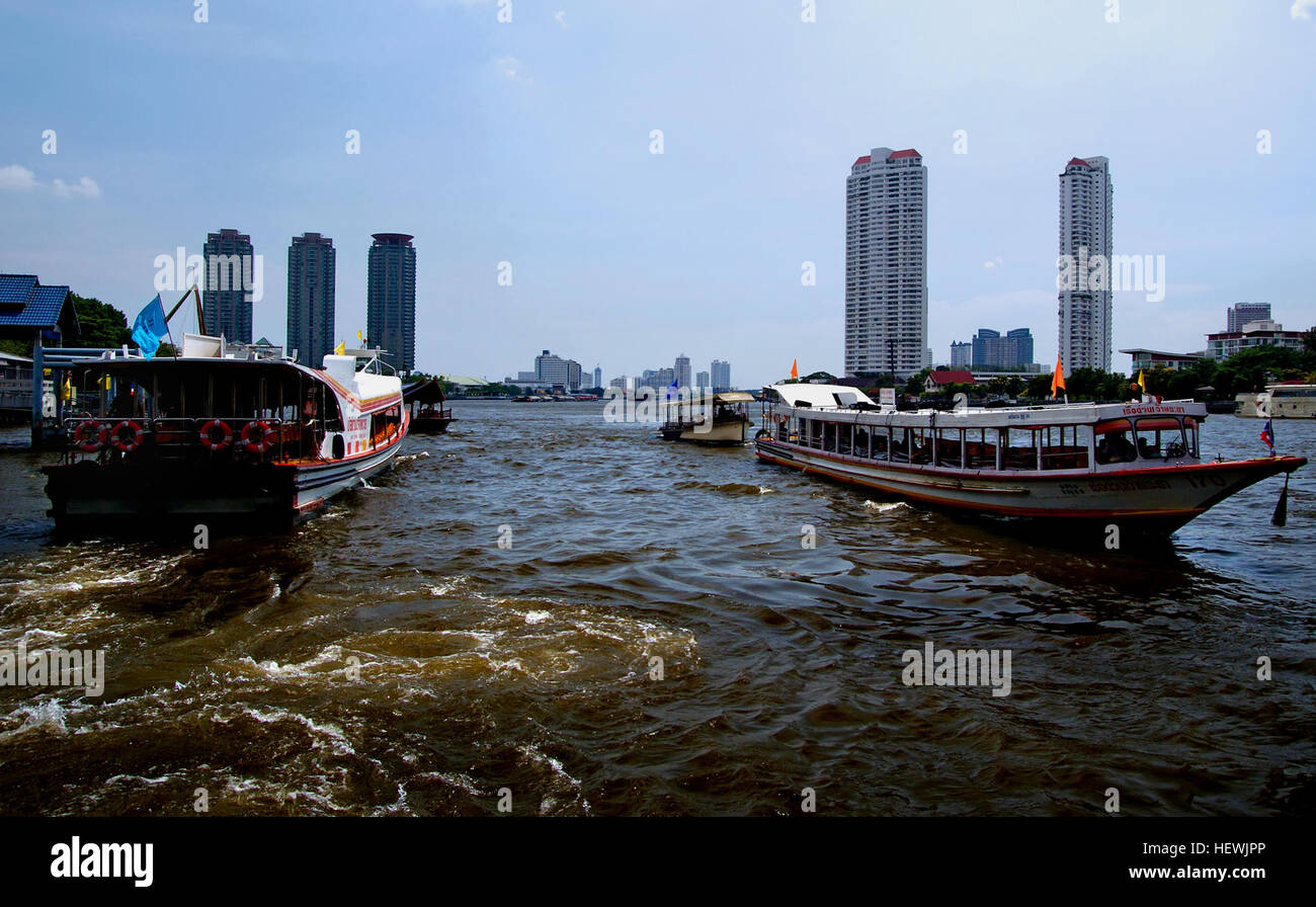 Una fotografia di una crociera fluviale a Bangkok, Thailandia. L'immagine cattura le viste panoramiche lungo il fiume, con le tradizionali barche thailandesi che navigano lungo i corsi d'acqua, offrendo una prospettiva unica dei monumenti e della cultura della città. Foto Stock