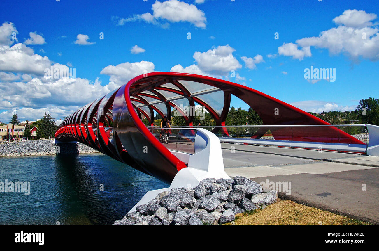 Il Peace Bridge di Calgary, progettato da Santiago Calatrava, è un ponte pedonale e ciclabile che attraversa il fiume Bow. Aperto il 24 marzo 2012, è conosciuto per il suo design rosso unico e l'architettura moderna. Foto Stock