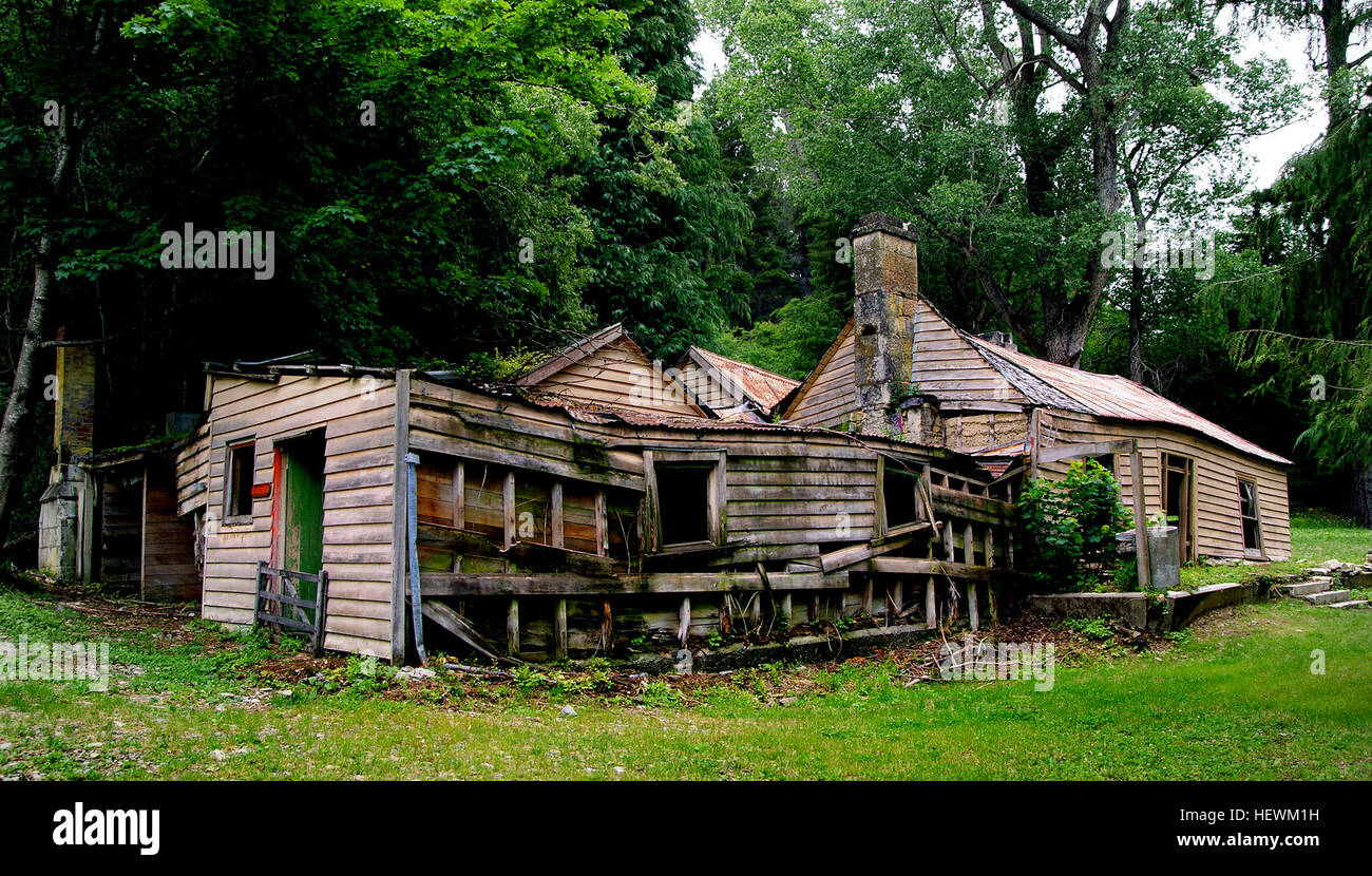 Una foto raffigurante una vecchia fattoria in rovina, che mostra gli effetti del tempo e dell'abbandono. La struttura è in uno stato di decadimento rurale, sottolineando il passare del tempo e i resti della fiorente vita rurale. Foto Stock