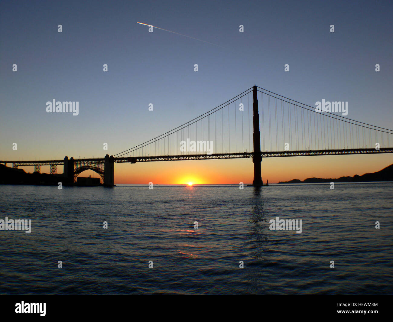 Una splendida foto del Golden Gate Bridge di San Francisco durante il tramonto, che cattura l'iconico ponte contro il cielo vibrante. L'immagine evidenzia la bellezza architettonica del ponte mentre contrasta con il cielo colorato. Foto Stock