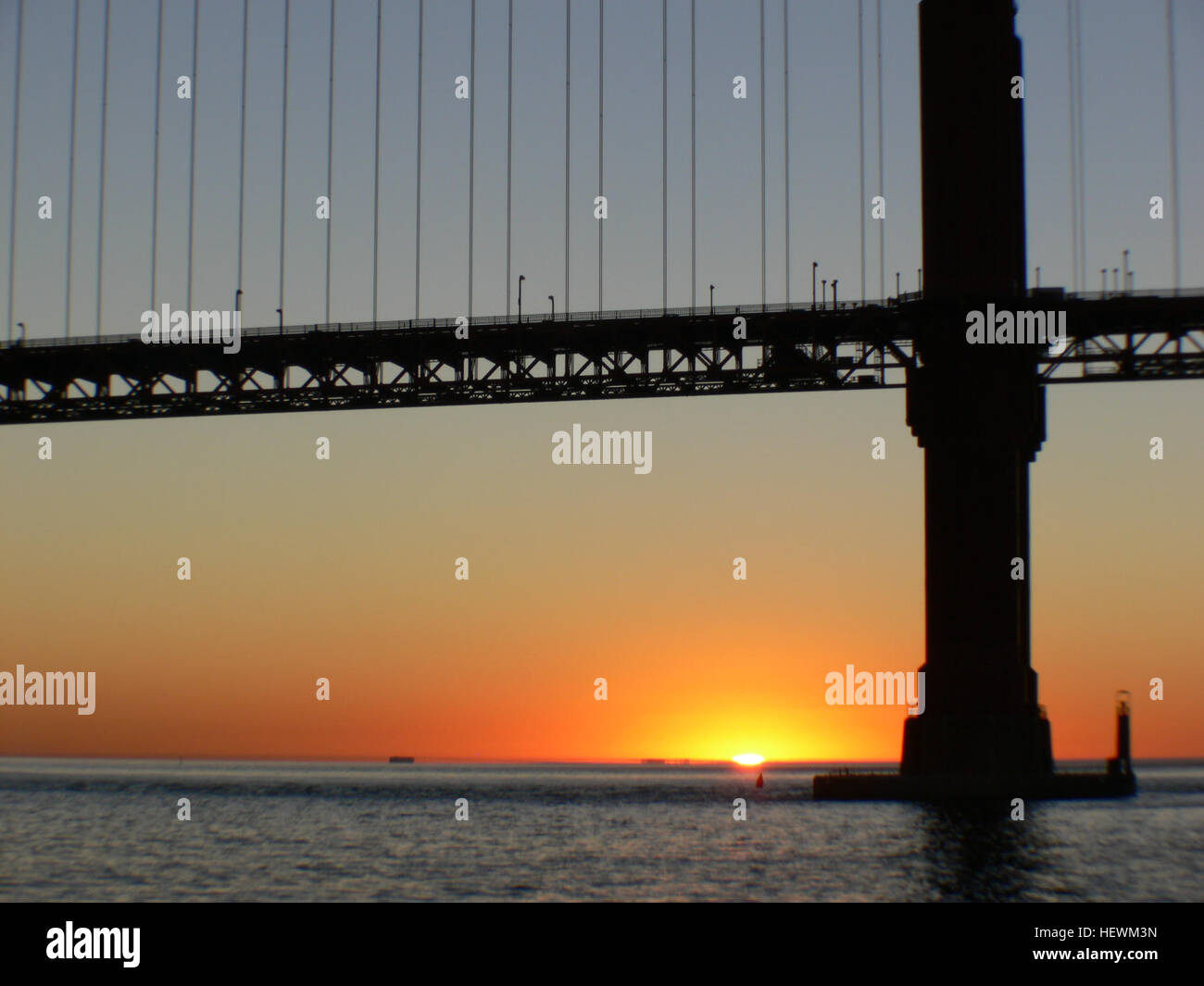 Il Golden Gate Bridge, una delle strutture più iconiche al mondo, è raffigurato al tramonto. Questa fotografia cattura la suggestiva silhouette del ponte sullo sfondo di un cielo vibrante, mostrando la sua bellezza architettonica e l'importanza come simbolo di San Francisco. Foto Stock
