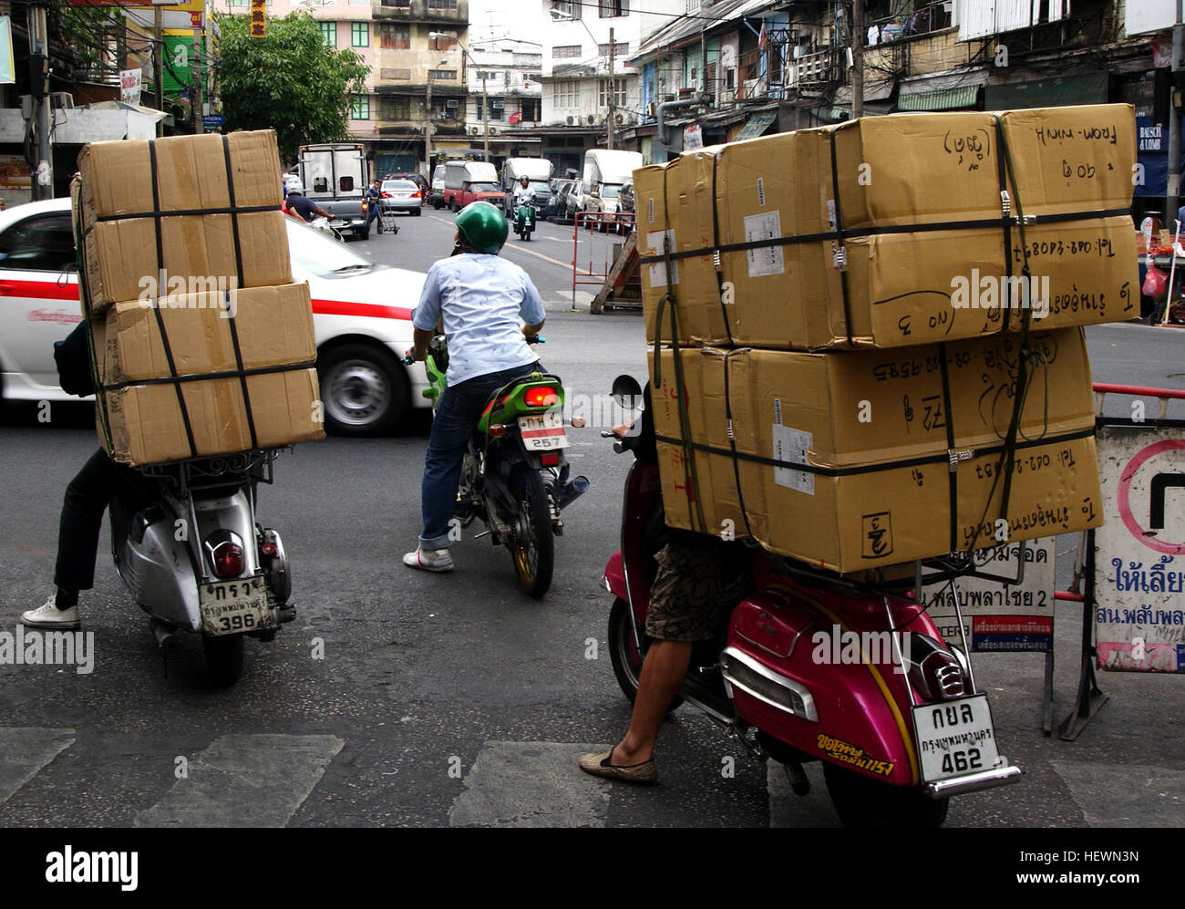 Una vivace scena di Bangkok, la capitale e la città più grande della Thailandia, che mostra la sua vivace vita di strada, le moto e il movimentato trasporto merci. Conosciuta come Krung Thep Maha Nakhon, Bangkok è un importante centro culturale e commerciale nel sud-est asiatico. Foto Stock