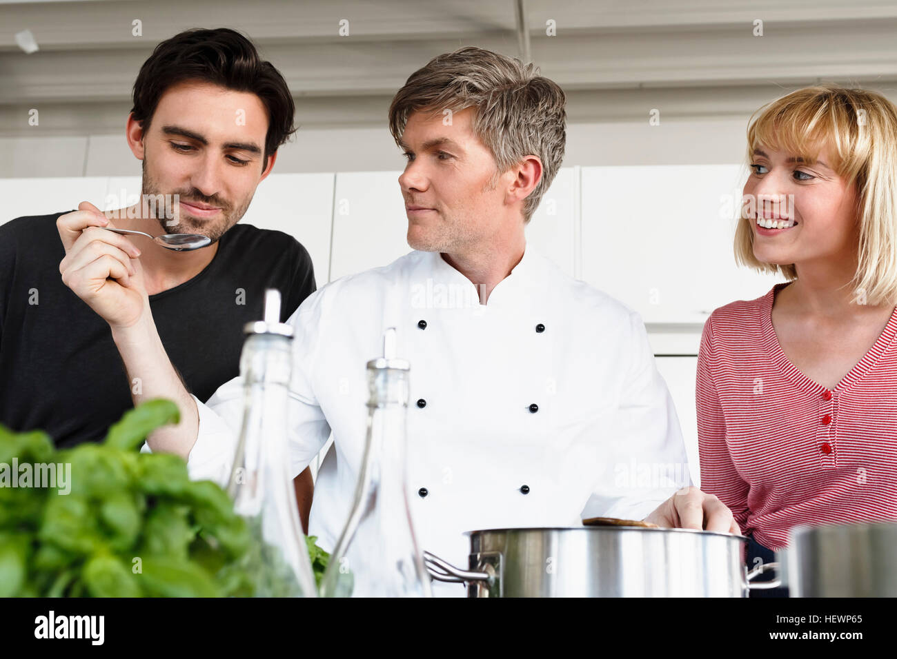 Lo chef e il giovane in cucina cibo degustazione Foto Stock