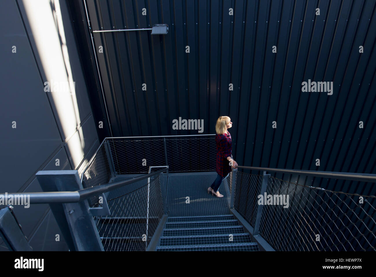 Donna che cammina giù le scale Foto Stock