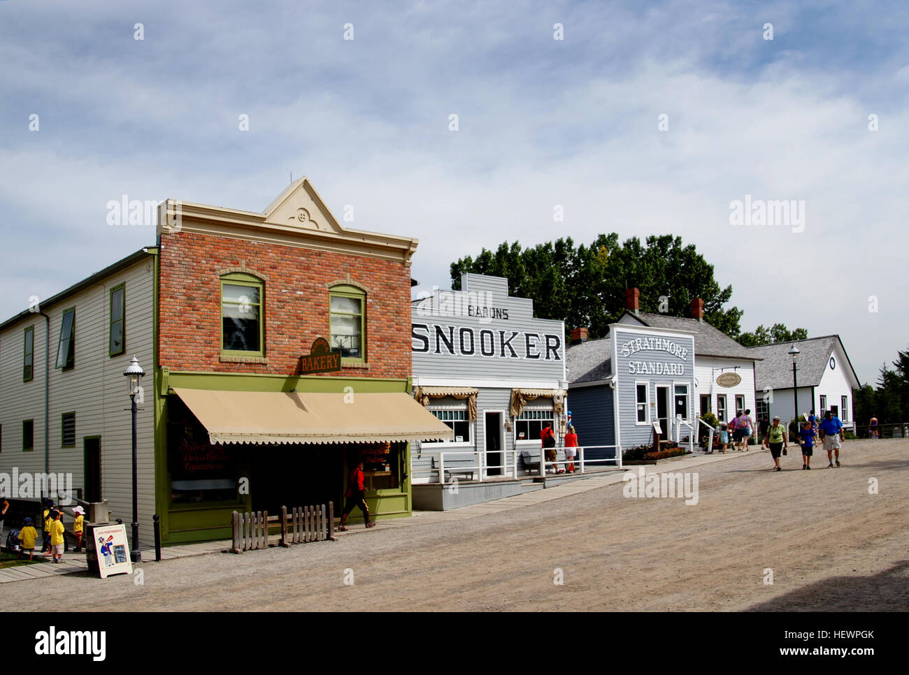 Questa immagine presenta il trasporto di prima mattina nell'Heritage Park, Calgary, tra cui carrozze trainate da cavalli e scene di strada d'epoca. Mostra veicoli storici e la vita di strada del passato, riflettendo il ricco patrimonio di Calgary. Foto Stock