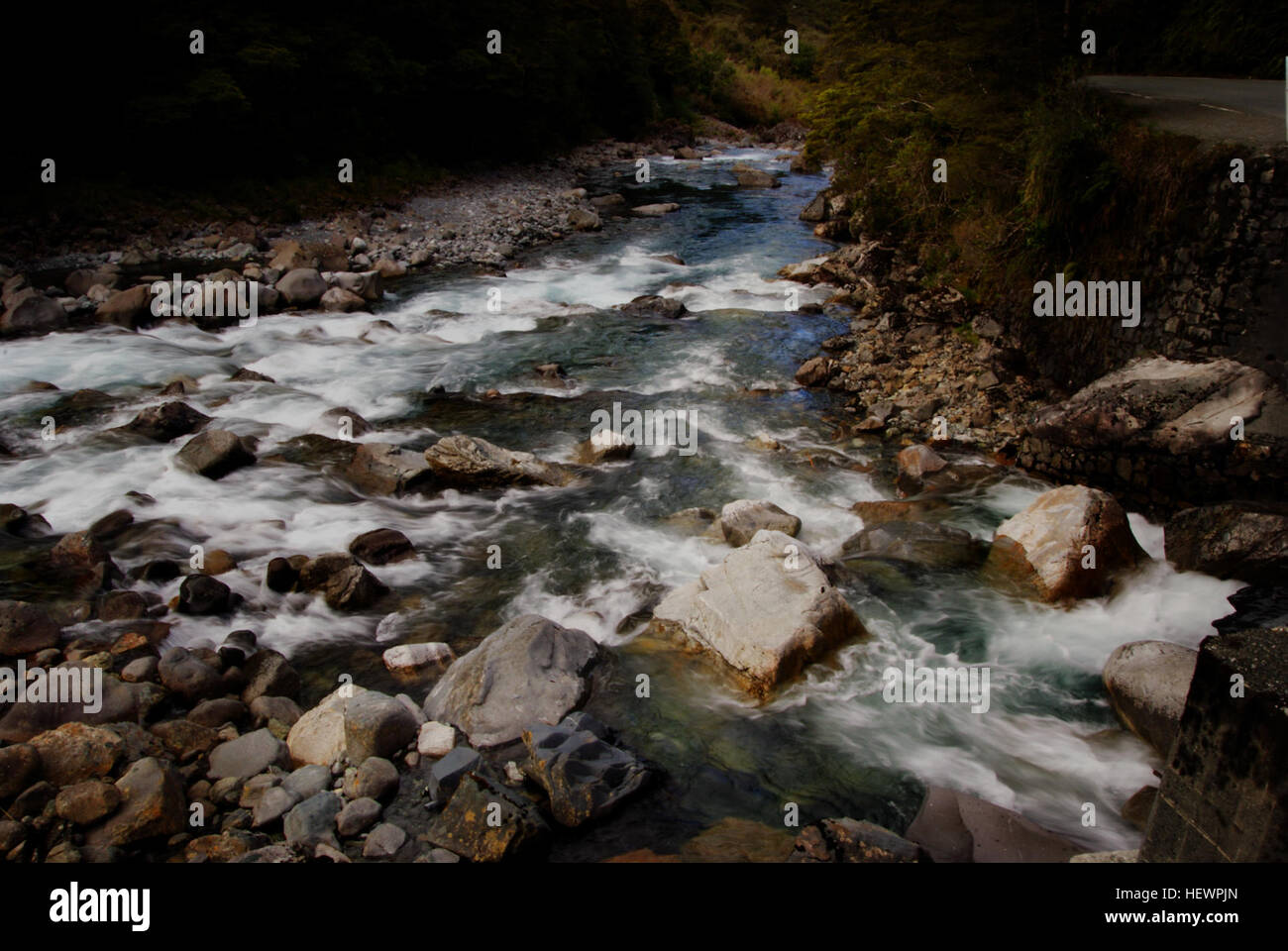 Una vista panoramica del fiume Hollyford, situato all'interno di un sito Patrimonio Mondiale dell'Umanita' in nuova Zelanda. Questo fiume incontaminato è noto per la sua bellezza naturale incontaminata, con acque fluide, fitte foreste e un ricco ecosistema, che lo rendono una destinazione chiave per gli amanti della natura e della conservazione ambientale. Foto Stock