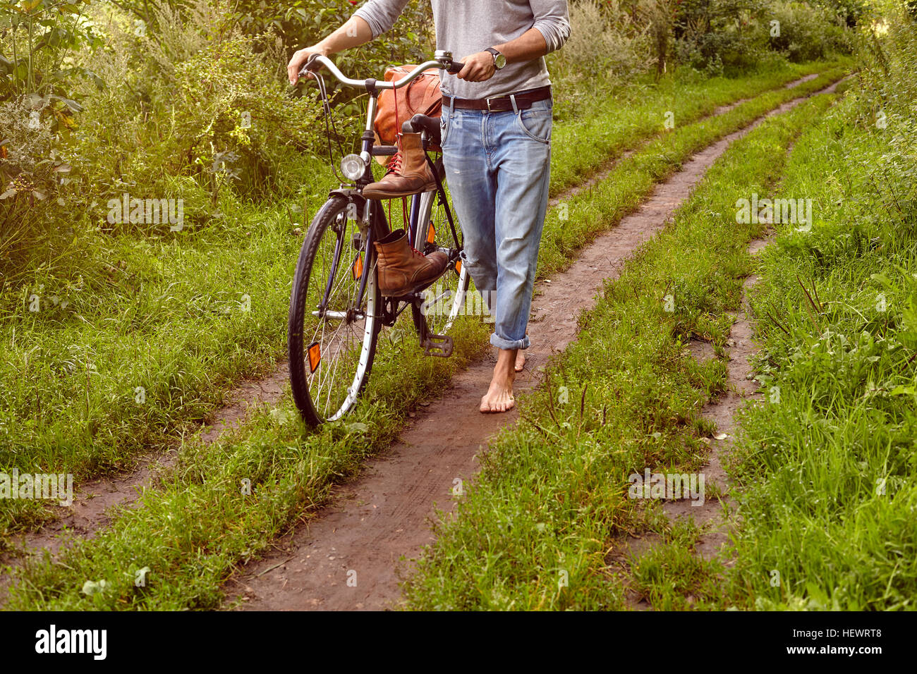 Collo in giù in vista dell uomo di spinta sulla bicicletta rurale traccia di sporco Foto Stock