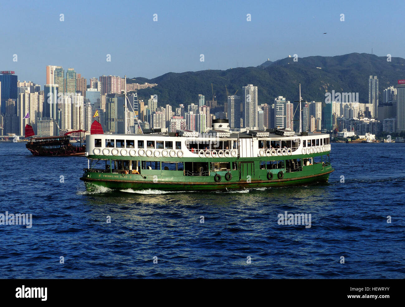 Lo Star Ferry di Hong Kong è un simbolo iconico della città, che collega l'isola di Hong Kong e Kowloon. Questi traghetti verdi e bianchi operano tutti i giorni dalla mattina presto fino a tarda notte, offrendo un'opzione di trasporto pratica e conveniente sia per la gente del posto che per i turisti. Il servizio è noto per la sua convenienza e l'attraversamento panoramico del Victoria Harbour. Foto Stock